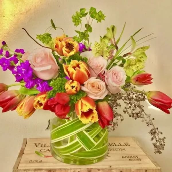 Mixed bouquet of tulips and roses in a glass vase