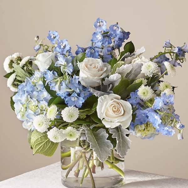 Blue and white flower arrangement in a clear glass vase