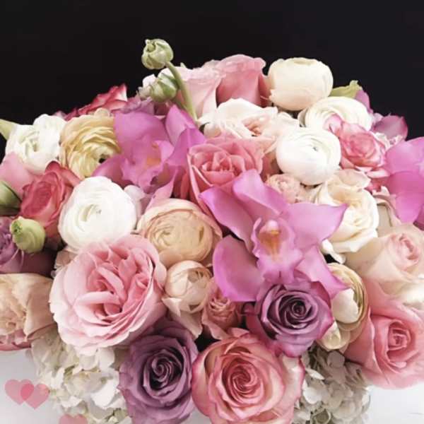 Pink and white roses with calla lilies in a round white box