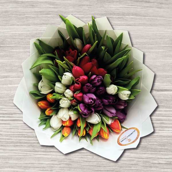 Bouquet of multicolored tulips wrapped in white paper