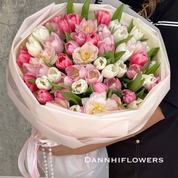 Bouquet of pink and white tulips wrapped in pale pink paper