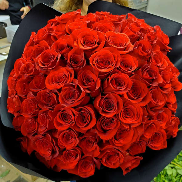 Large bouquet of red roses wrapped in black paper