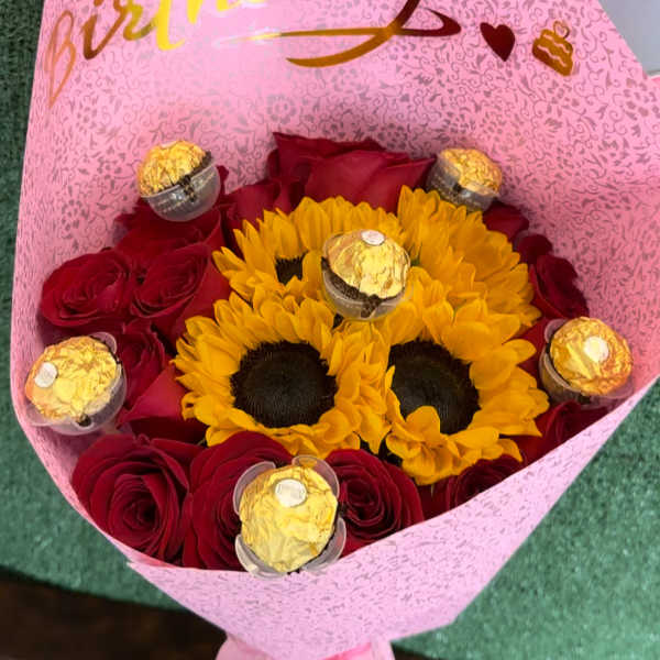 Bouquet of red roses and yellow sunflowers with chocolates in pink wrap