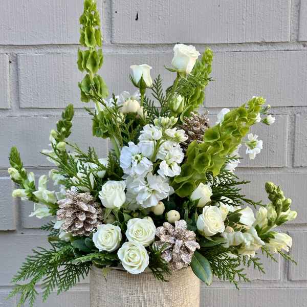 White roses and snapdragons in a beige textured vase