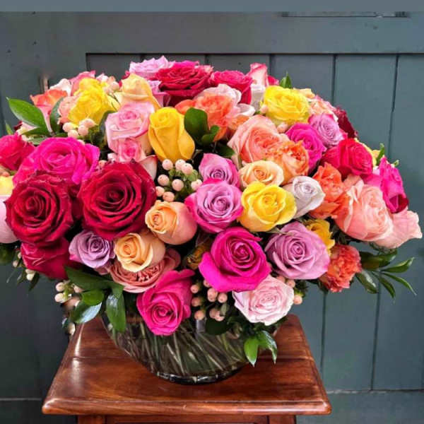 Large bouquet of multicolored roses in a glass vase