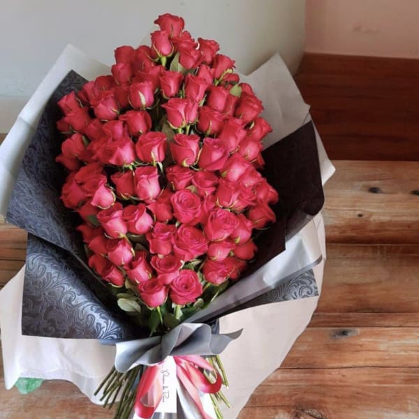 Large bouquet of pink roses wrapped in black and white paper