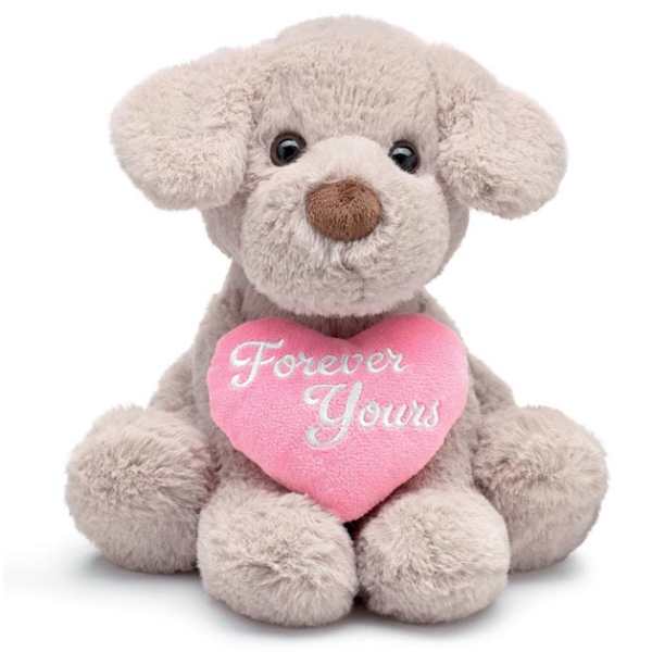 Tan plush puppy holding a pink heart pillow that says Forever Yours.