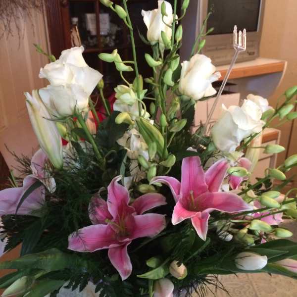 Pink and white lilies arranged in a clear glass vase