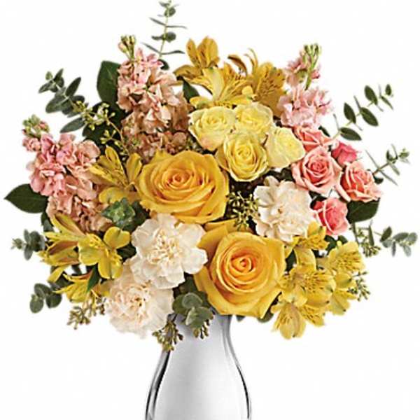 Yellow and pink mixed flower bouquet in a clear glass vase