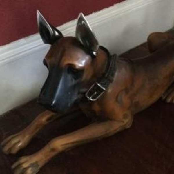 A brown dog sculpture lying on a dark surface