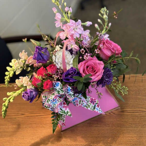 Pink and purple mixed bouquet in a pink gift box with a patterned ribbon