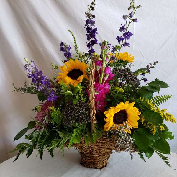 Basket arrangement with sunflowers, purple blooms, and pink flowers