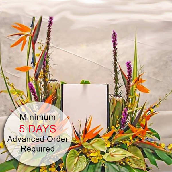 Tropical arrangement with orange birds of paradise, green anthuriums, yellow orchids and tall purple spikes around a blank card.