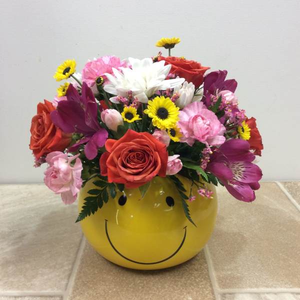 Mixed bouquet in a yellow smiley-face container