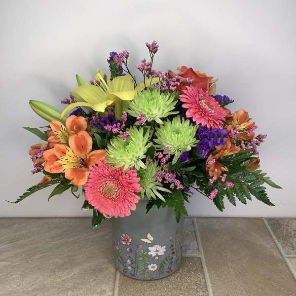 Colorful mixed bouquet in a floral tin container