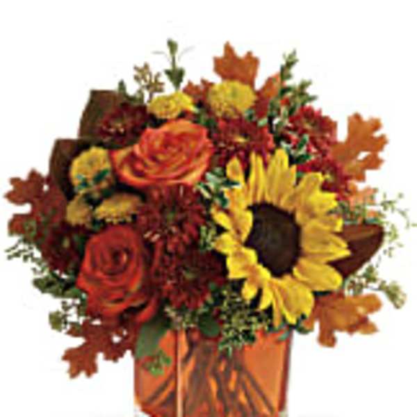 Autumn bouquet with sunflowers and roses in an orange vase