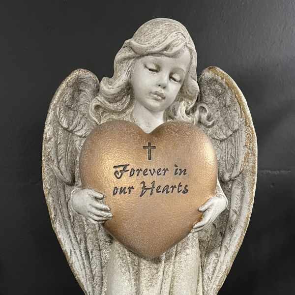 Angel figurine holding a heart plaque with the words Forever in our Hearts