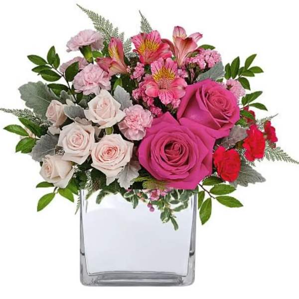 Pink and white rose bouquet in a clear square vase
