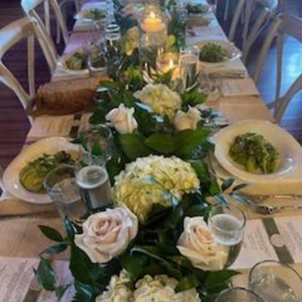 Long banquet table with white floral centerpieces and candles