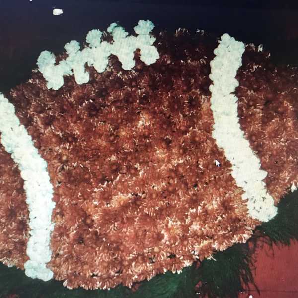 Football-shaped floral arrangement in brown and white flowers