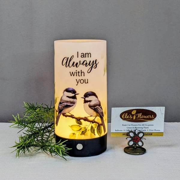 Lit memorial candle with two birds and the words "I am always with you"