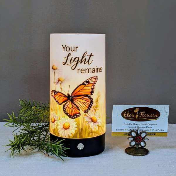 Butterfly memorial candle with daisies and the words 'Your Light remains'