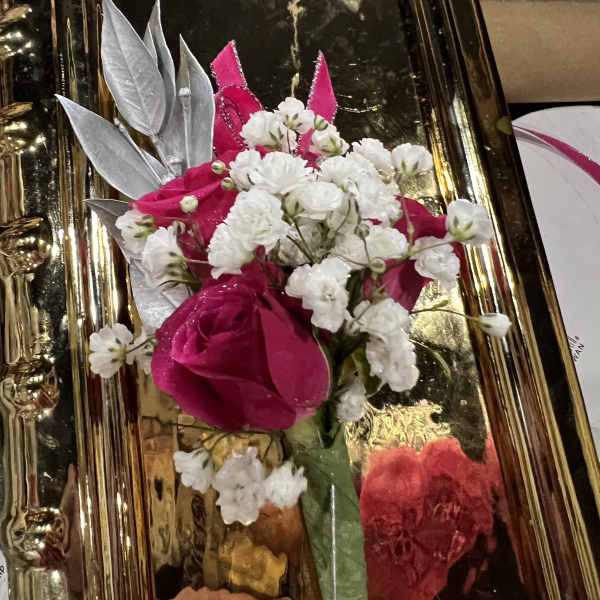 Pink rose boutonniere with white baby's breath on a gold tray