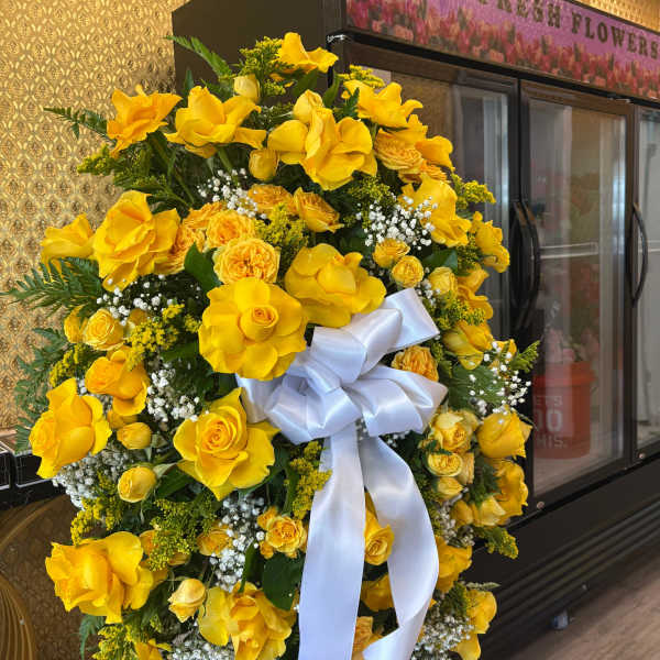 Large yellow floral wreath with a white ribbon bow