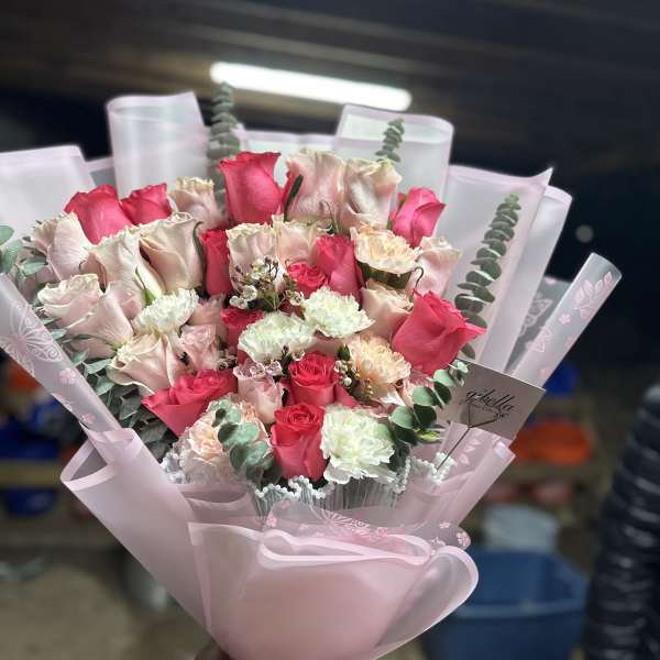 Pink and white rose bouquet wrapped in pale pink paper