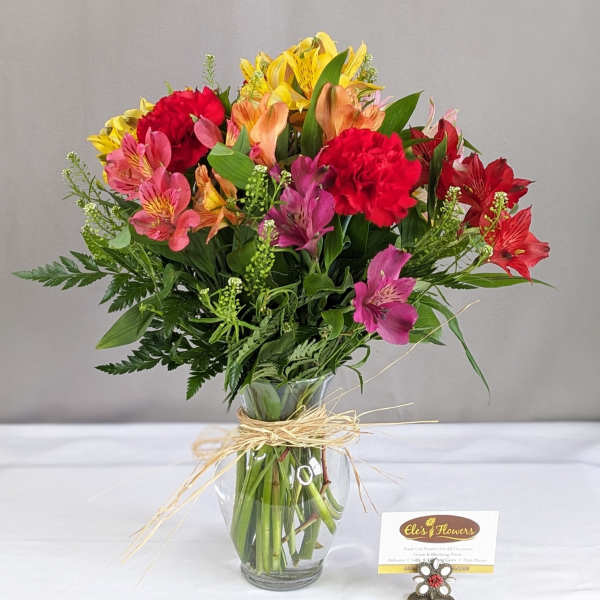Mixed bouquet of colorful flowers in a clear glass vase