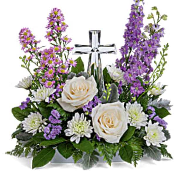 White and purple flower arrangement with a crystal cross in the center