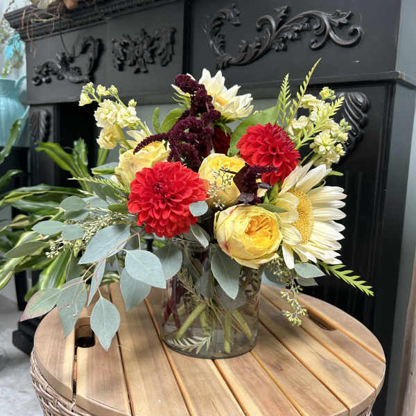 Bouquet of red, yellow, and white flowers in a glass vase