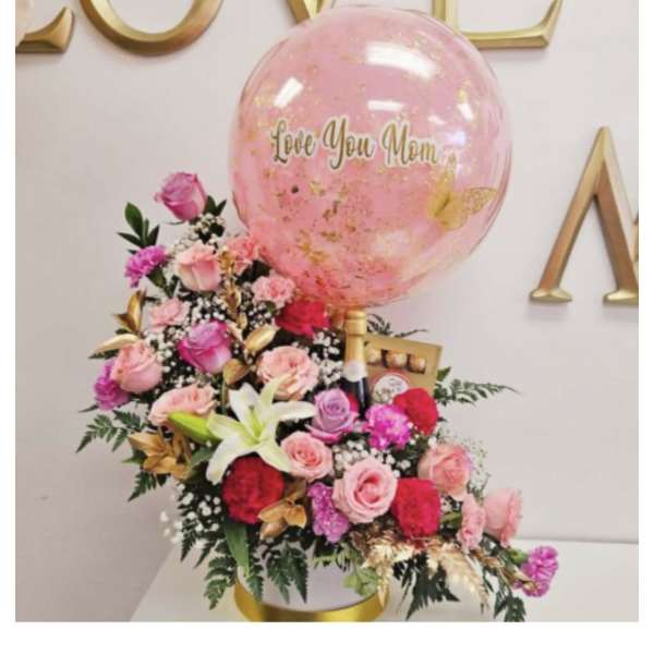 Pink rose arrangement with a large balloon reading Love You Mom