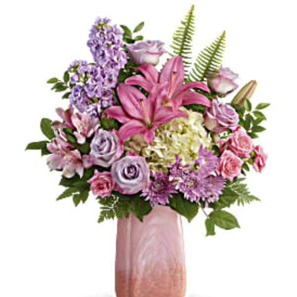 Pink lilies and lavender flowers in a tall pink vase