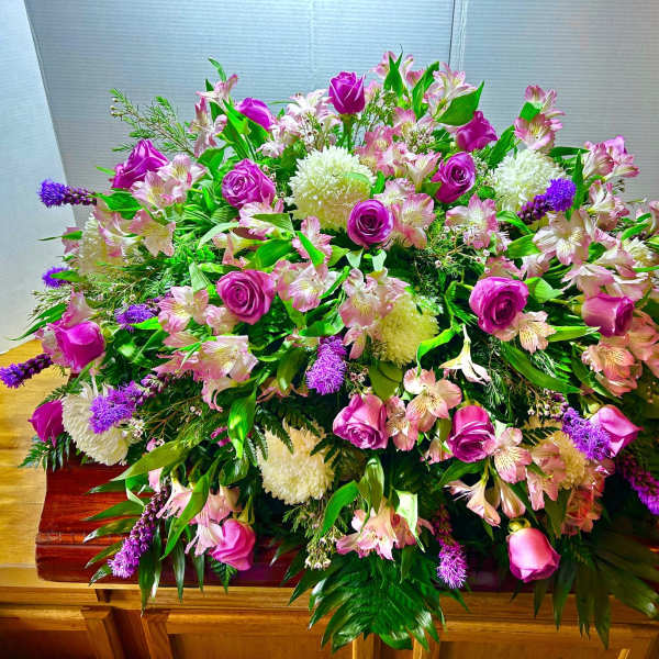 Large pink and purple floral casket spray with roses and alstroemeria
