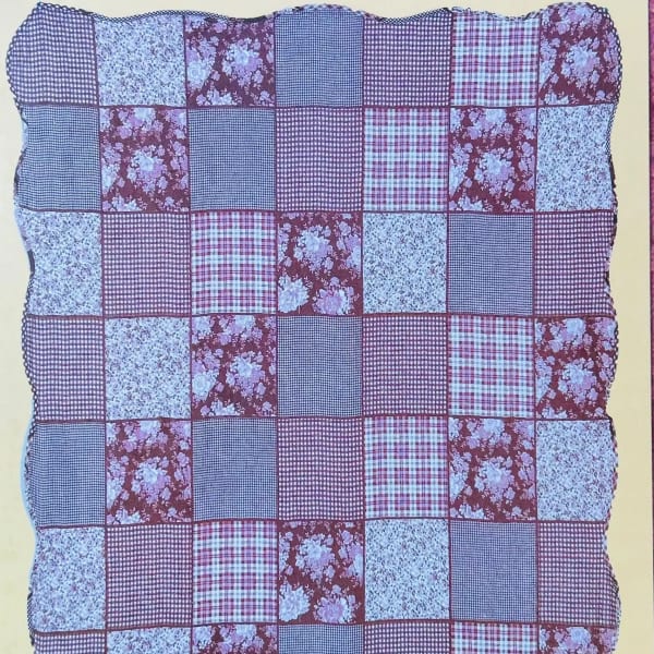 Patchwork quilt with red, blue, and floral fabric squares