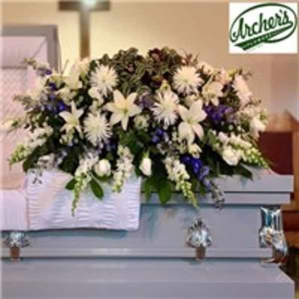 Large white and purple funeral spray on a casket