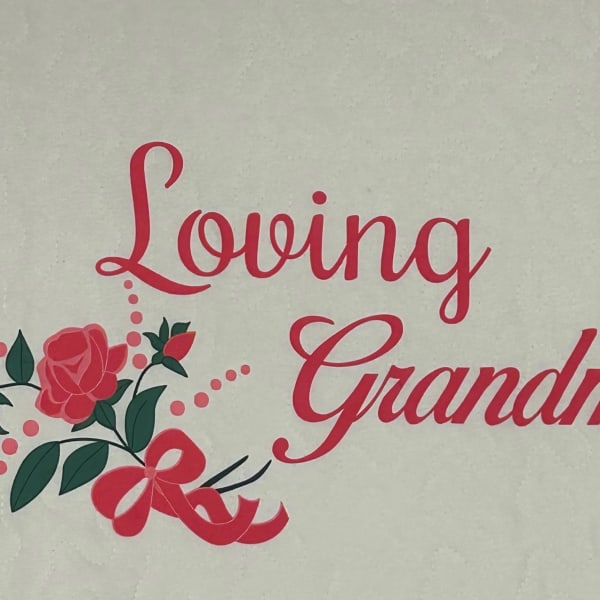 Quilted fabric with pink "Loving Grandma" text and rose graphics