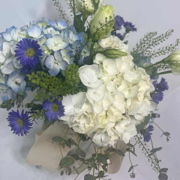 Bouquet of blue hydrangeas, white blooms, and purple daisies