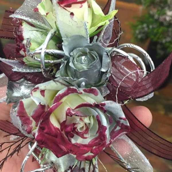 Small hand-held corsage with burgundy and silver roses