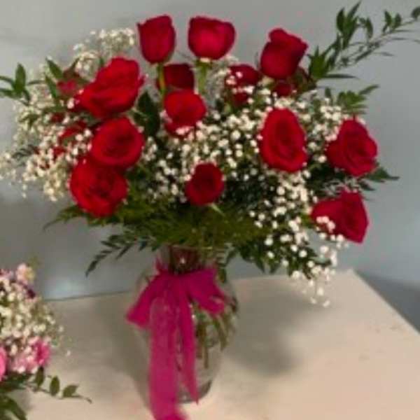 Bouquet of red roses with white baby's breath in a glass vase