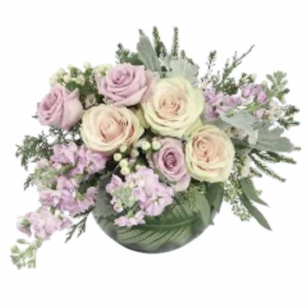 Bouquet of pale pink and cream roses with lavender flowers in a green vase