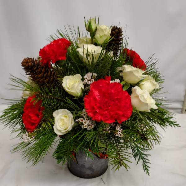 Red and white roses with carnations in a small vase