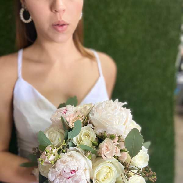 Bride holding a pale pink and white bouquet with eucalyptus