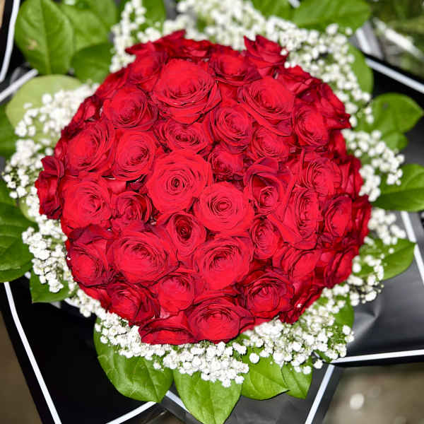 Round bouquet of red roses with white baby's breath