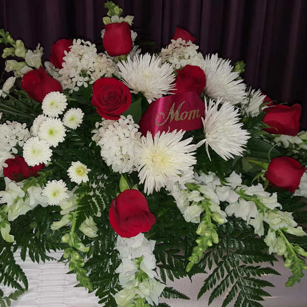 Red roses and white chrysanthemums arranged on a casket