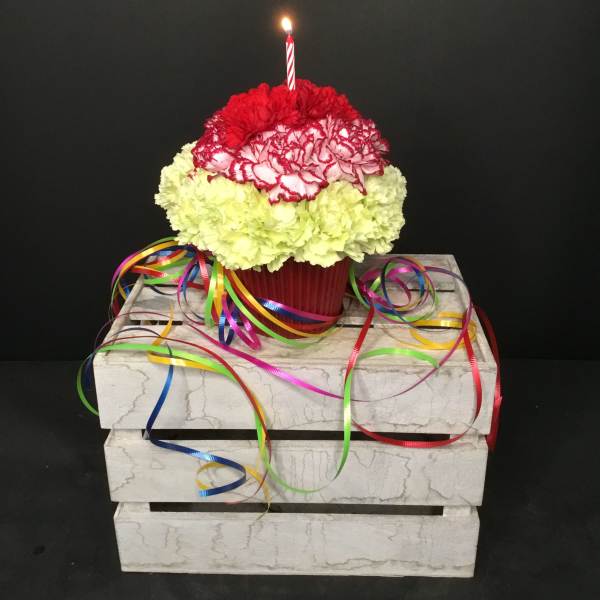 Carnation cupcake arrangement with a lit candle and colorful ribbons