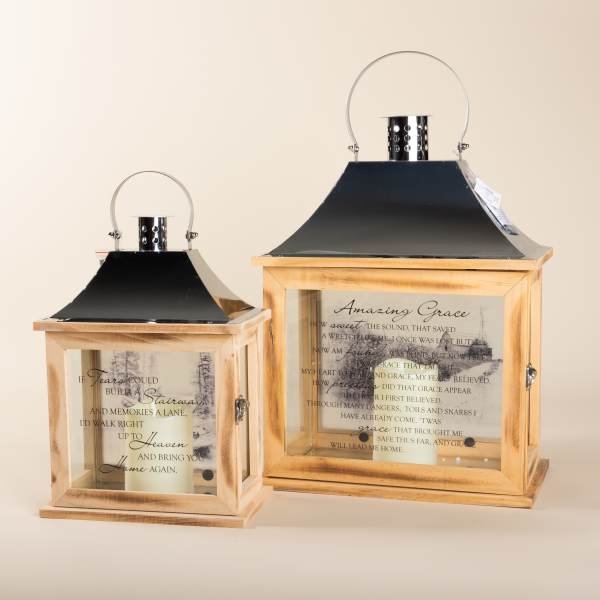 Two wooden lanterns with candles and memorial text