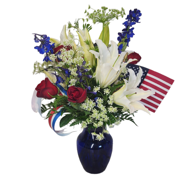 Red roses and white lilies in a blue vase with an American flag
