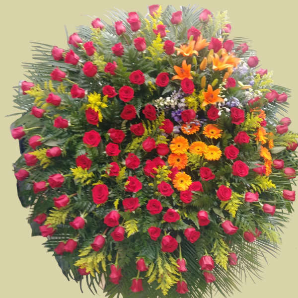 Large standing spray of red roses with orange lilies and yellow filler flowers